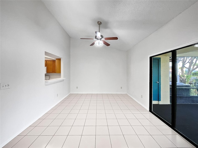 spare room with lofted ceiling, a textured ceiling, light tile patterned floors, and ceiling fan