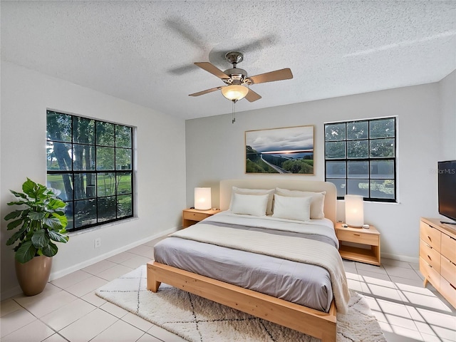 bedroom featuring a textured ceiling, light tile patterned flooring, and ceiling fan