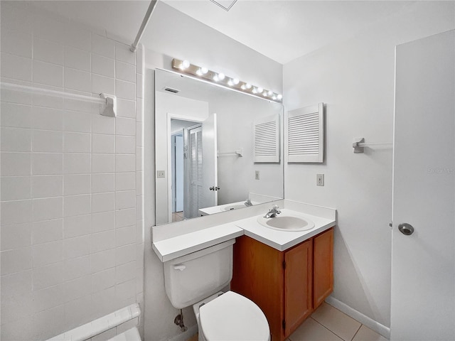 bathroom with vanity, toilet, tile patterned floors, and tiled shower