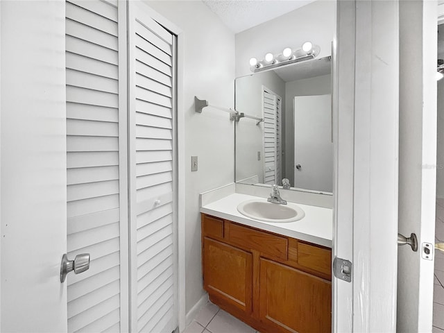 bathroom with vanity, a textured ceiling, and tile patterned flooring