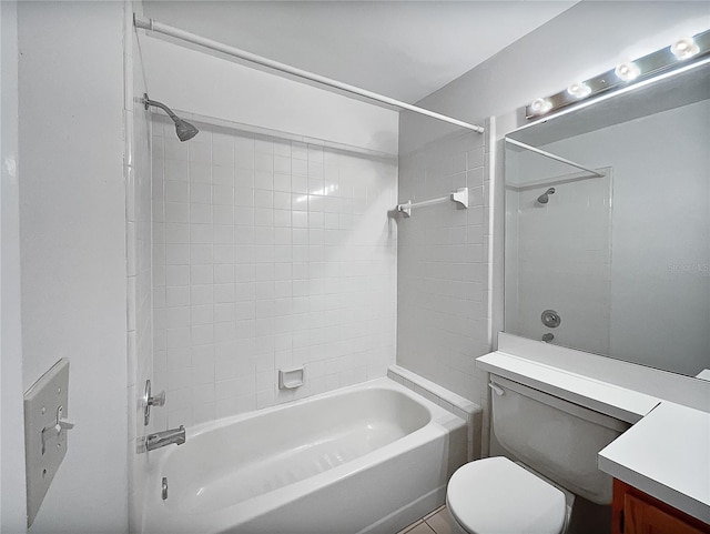 full bathroom featuring tiled shower / bath, vanity, and toilet