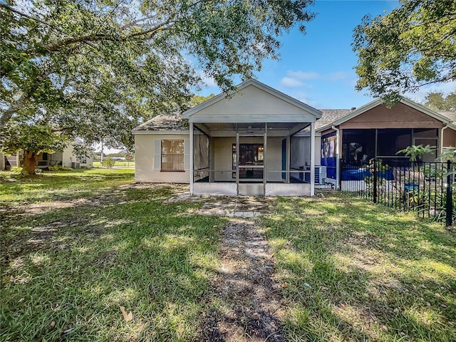 rear view of house with a yard and a sunroom