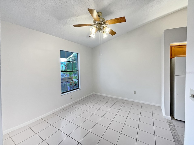 spare room with ceiling fan, a textured ceiling, and light tile patterned floors