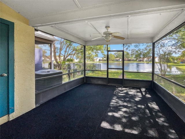 unfurnished sunroom featuring a water view and ceiling fan