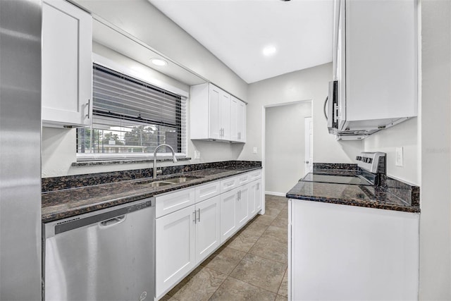 kitchen featuring white cabinetry, stainless steel appliances, sink, and dark stone countertops