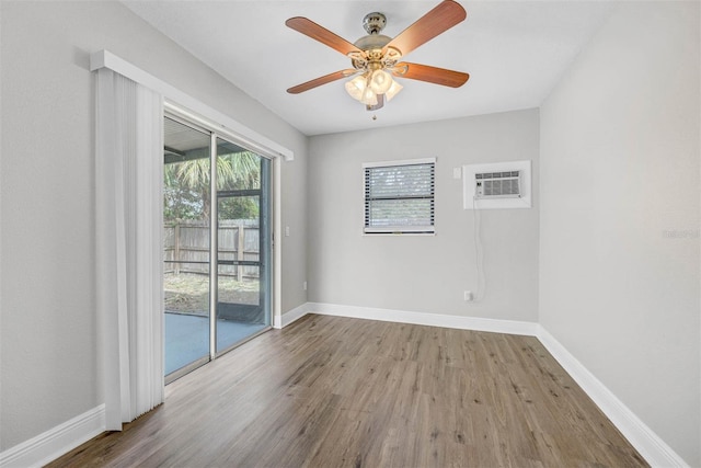 spare room with light hardwood / wood-style floors, an AC wall unit, and ceiling fan