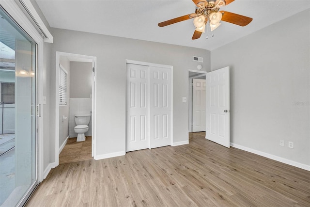 unfurnished bedroom with ensuite bath, tile walls, light hardwood / wood-style floors, and ceiling fan