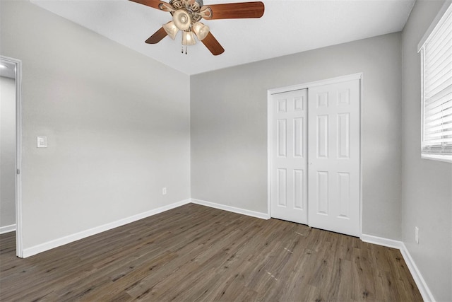 unfurnished bedroom with dark hardwood / wood-style flooring, a closet, and ceiling fan