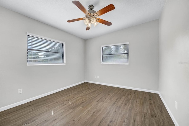 unfurnished room with dark hardwood / wood-style floors, a textured ceiling, and ceiling fan