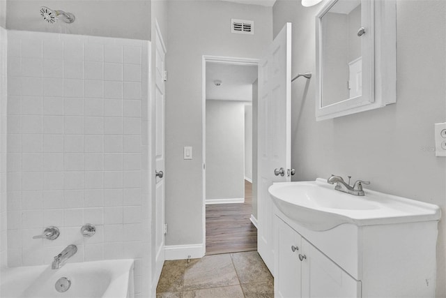 bathroom with vanity, tiled shower / bath, and hardwood / wood-style floors