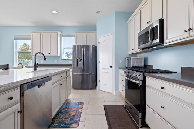 kitchen featuring sink, light tile patterned floors, stainless steel appliances, and a wealth of natural light