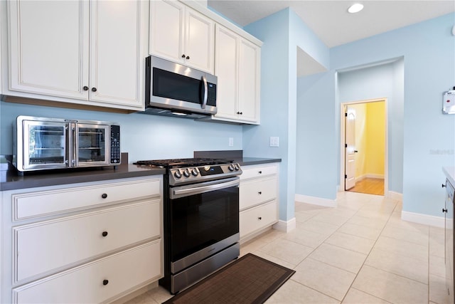 kitchen with white cabinets, light tile patterned floors, and stainless steel appliances