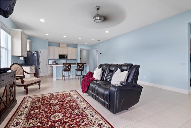 living room featuring ceiling fan and light tile patterned flooring