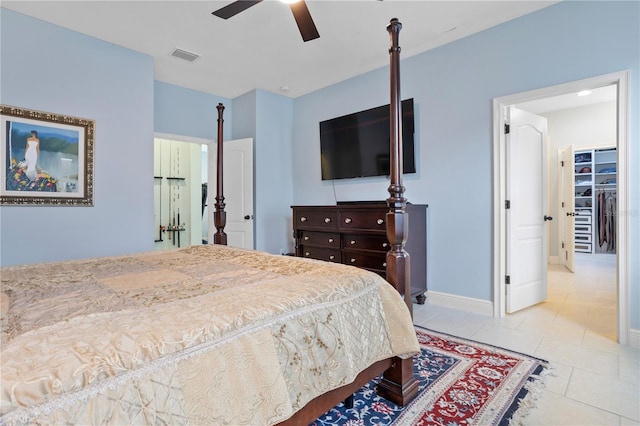 bedroom featuring ceiling fan, light tile patterned flooring, a spacious closet, and a closet