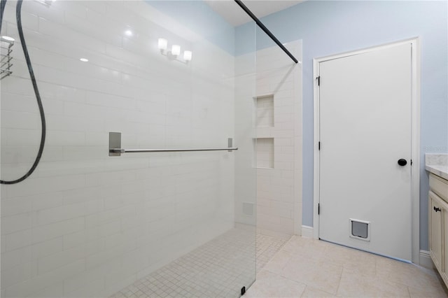 bathroom with tiled shower, vanity, and tile patterned floors