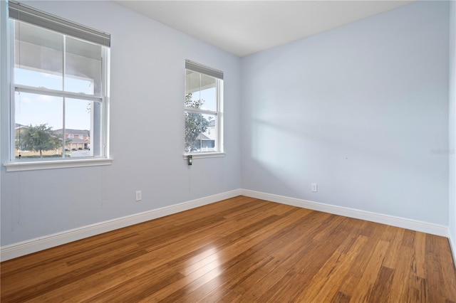 spare room featuring wood-type flooring and a wealth of natural light