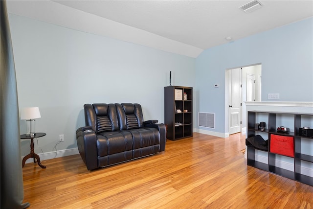 sitting room with light hardwood / wood-style floors and vaulted ceiling