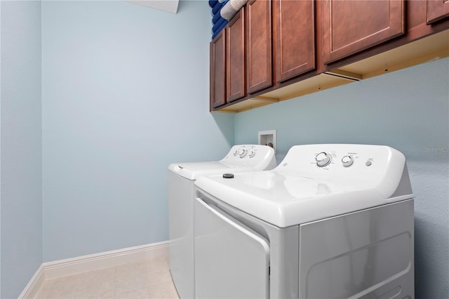 clothes washing area with washer and dryer and cabinets