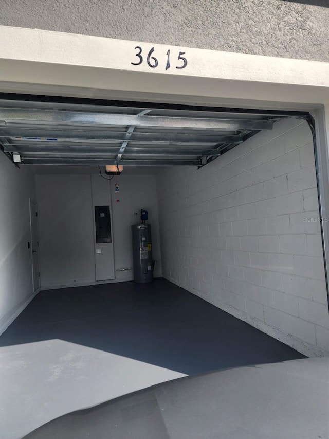 garage with a garage door opener, electric water heater, and electric panel