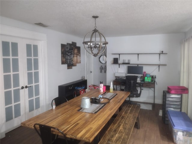 dining area featuring hardwood / wood-style floors, a textured ceiling, and a chandelier