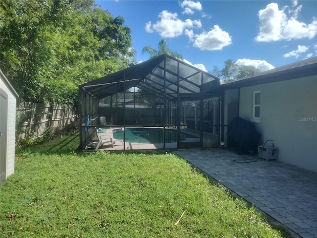 view of yard with glass enclosure, a patio, and a fenced in pool