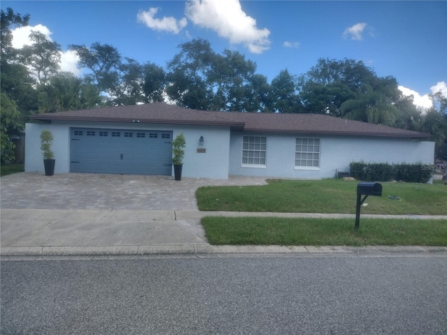 single story home featuring a front lawn and a garage