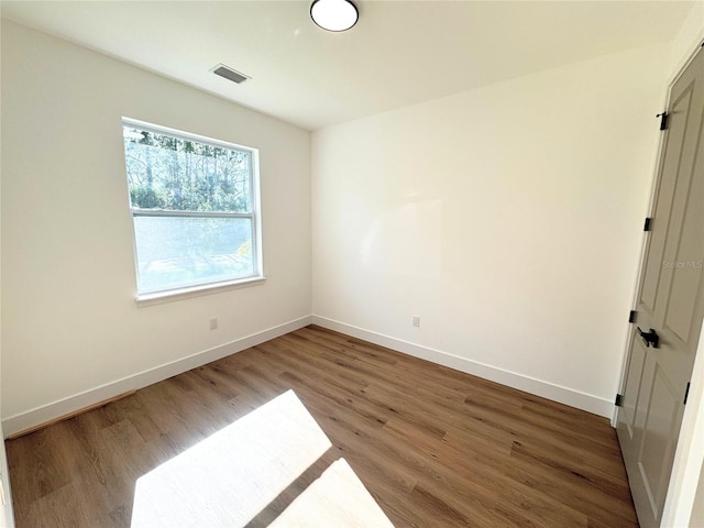 unfurnished room with wood-type flooring