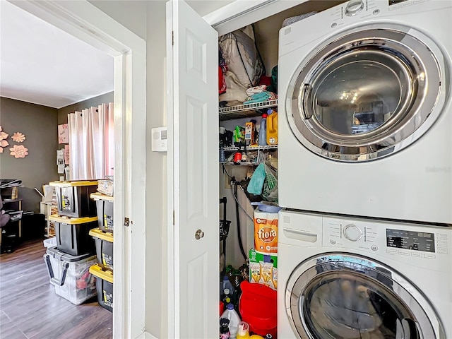 clothes washing area with stacked washer and clothes dryer and dark hardwood / wood-style floors