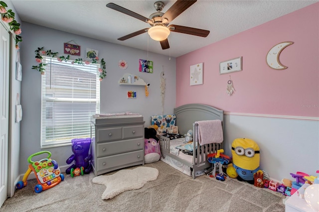 bedroom with a textured ceiling, carpet floors, and ceiling fan