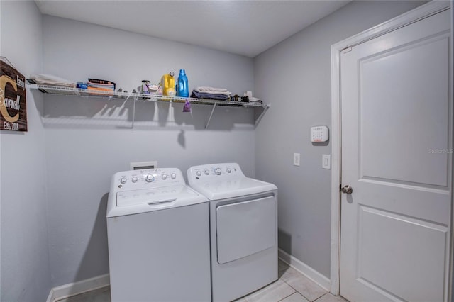 laundry room featuring washer and dryer and light tile patterned floors