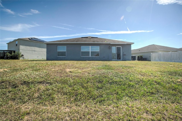 back of house featuring a lawn