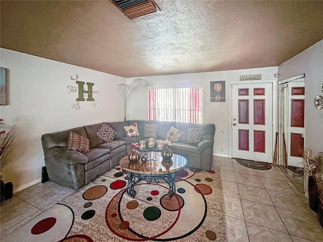 living room featuring a textured ceiling and light tile patterned floors