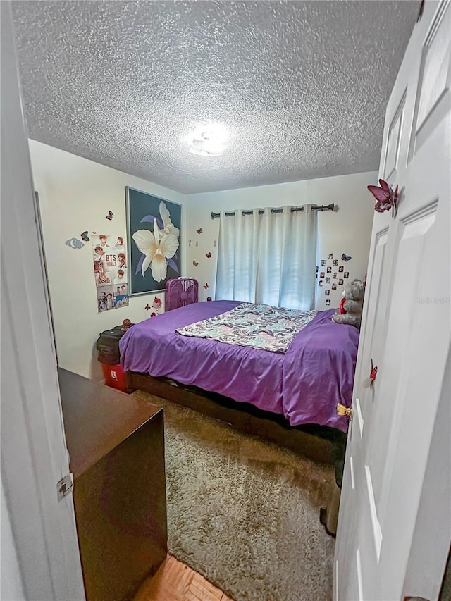 bedroom with parquet flooring and a textured ceiling