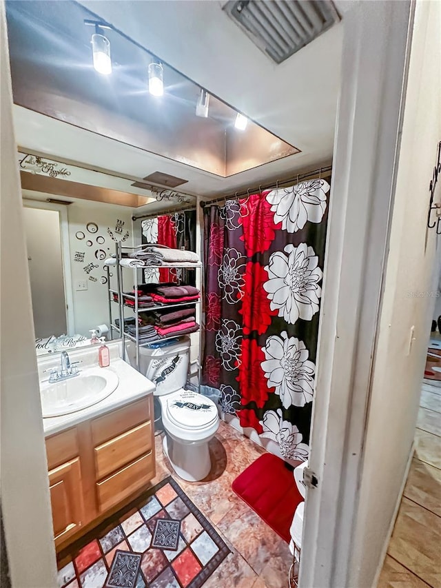 bathroom with vanity, toilet, and tile patterned floors