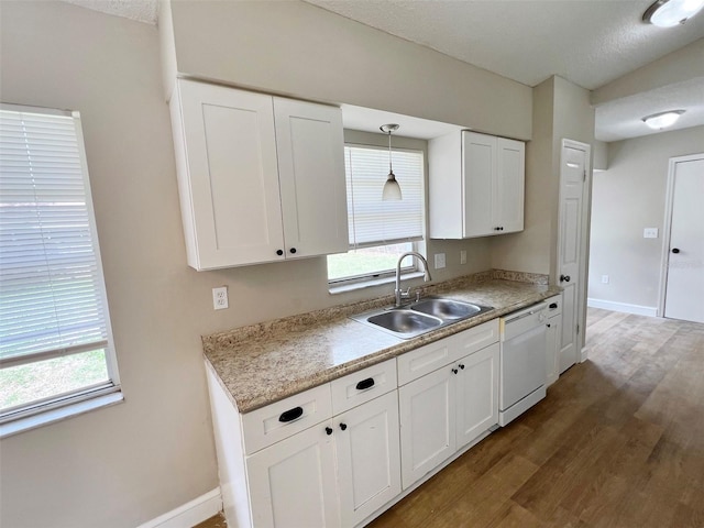 kitchen featuring white cabinets, dishwasher, dark wood-type flooring, pendant lighting, and sink