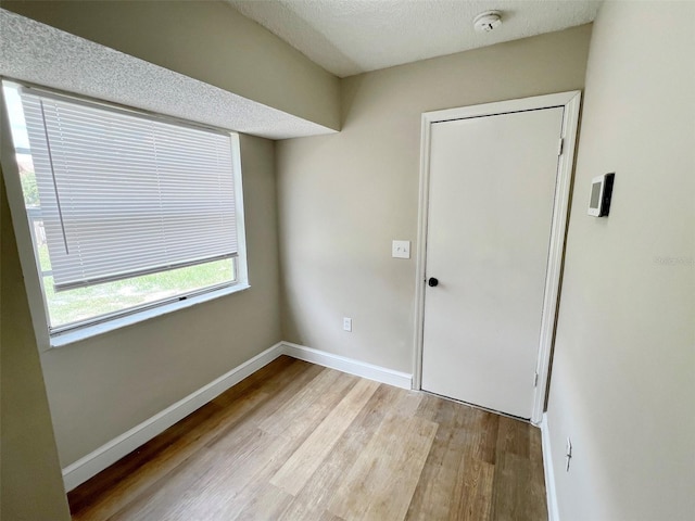 entryway with a textured ceiling and light wood-type flooring