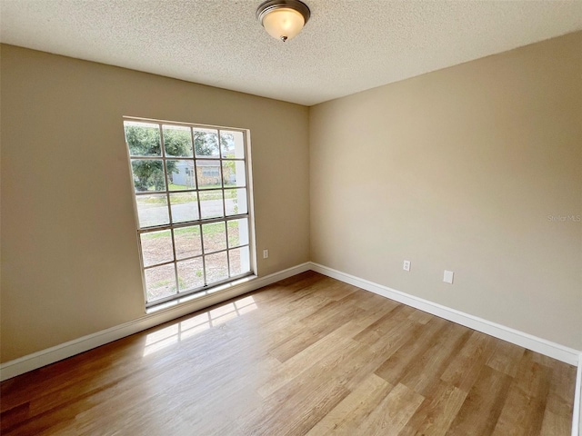 unfurnished room featuring light hardwood / wood-style flooring and a textured ceiling