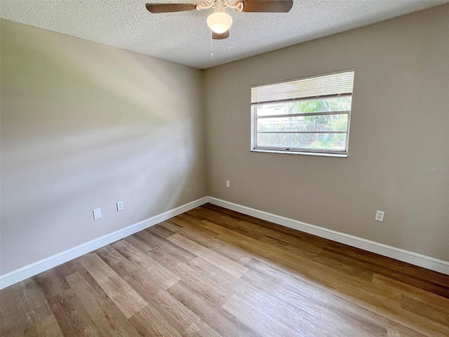 spare room with light hardwood / wood-style floors, a textured ceiling, and ceiling fan