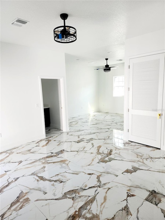 interior space with ceiling fan and a textured ceiling