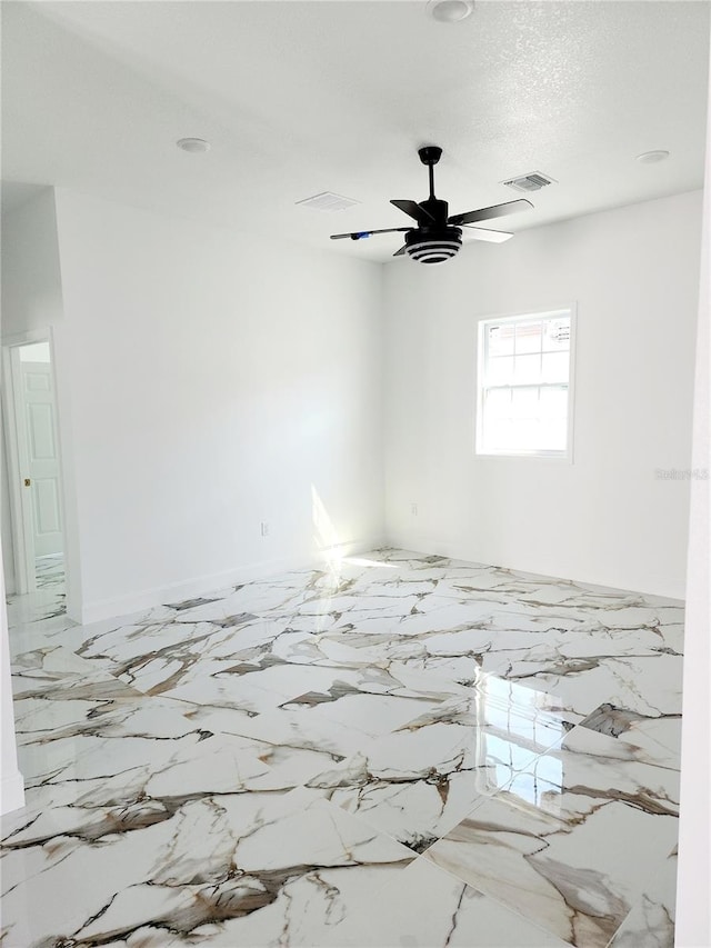 spare room featuring a textured ceiling and ceiling fan