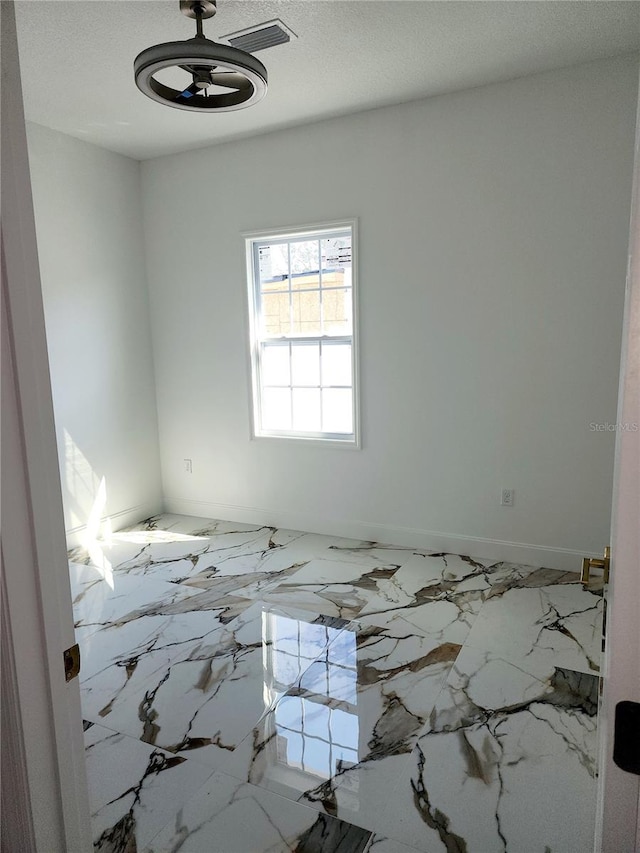 spare room with a textured ceiling