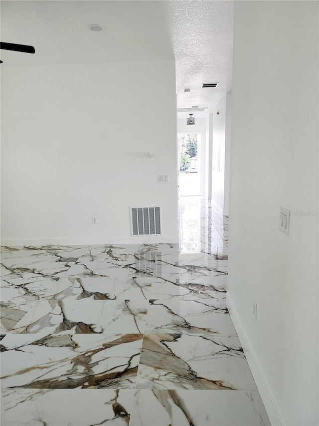 unfurnished room featuring a textured ceiling