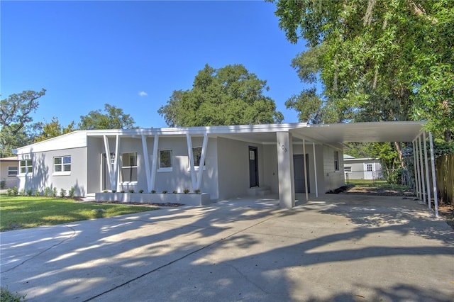 manufactured / mobile home with a carport and a front lawn