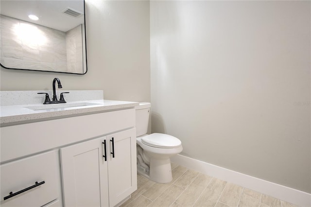 bathroom with vanity, wood-type flooring, and toilet