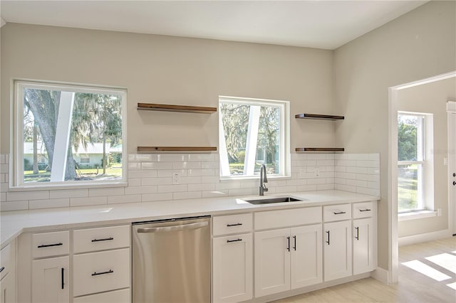 kitchen with plenty of natural light, decorative backsplash, sink, and stainless steel dishwasher