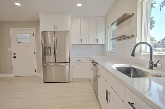 kitchen with sink, white cabinets, stainless steel appliances, and plenty of natural light