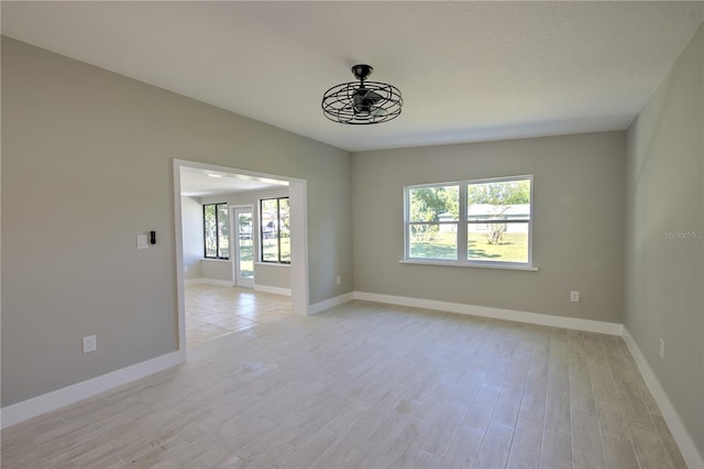 empty room featuring light wood-type flooring and ceiling fan