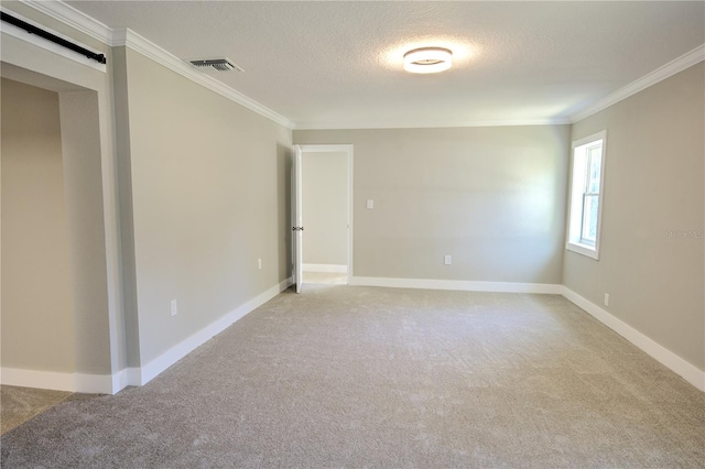 carpeted empty room featuring ornamental molding and a textured ceiling