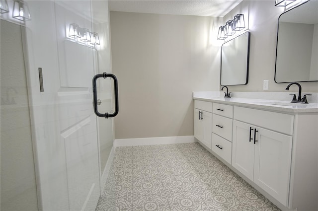 bathroom with vanity, walk in shower, and a textured ceiling