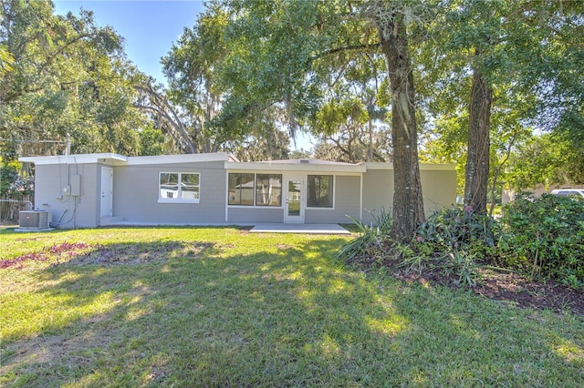 rear view of property featuring a patio, a lawn, and central AC unit